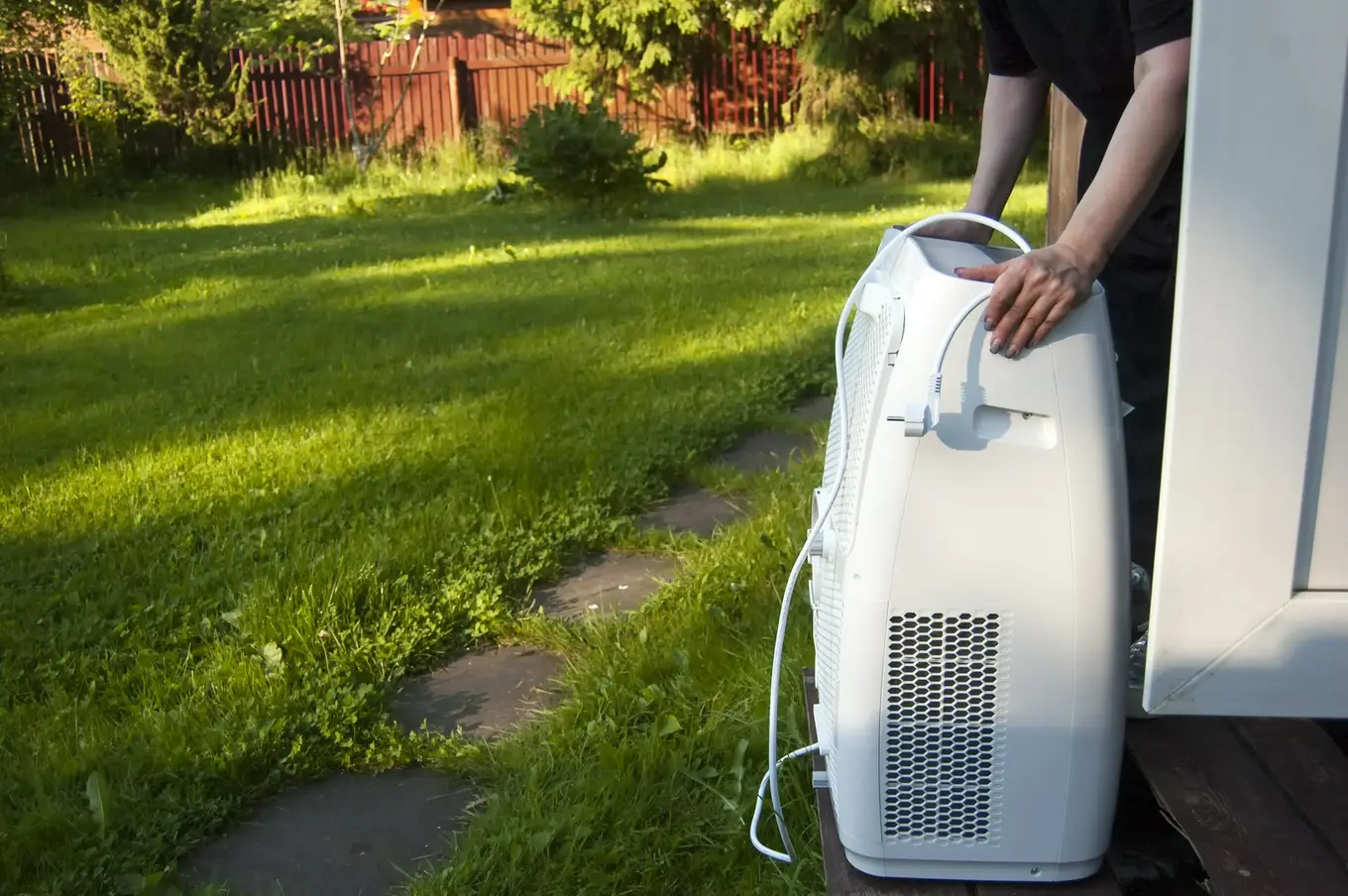 mężczyzna wnosi klimatyzator do domu